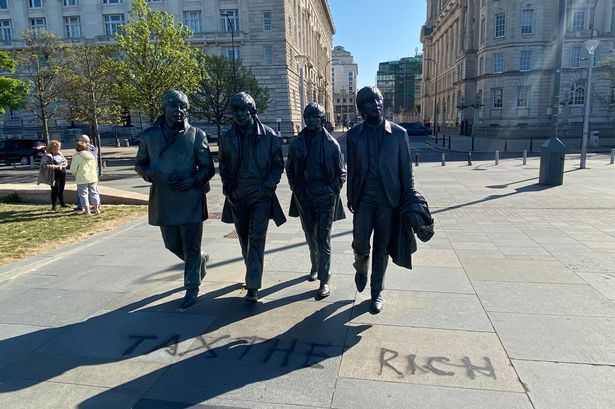 'Tax the rich' has been written on the floor at The Beatles statue on Liverpool's Pier Head