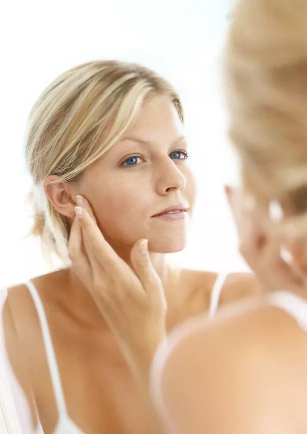 Woman gazing at herself lovingly in the mirror