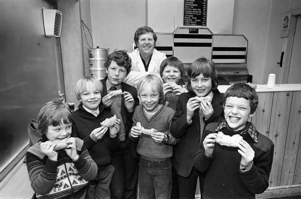 Battered jam butties are the specialty at the fish and chip shop on Railway Road, Chorley.  Owner David Barrow is pictured with some children who are enjoying the sandwich. March 1981.