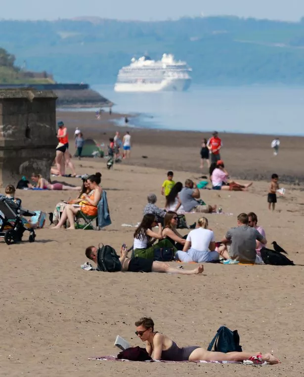 An image of a beach busy with people sunbathing and playing