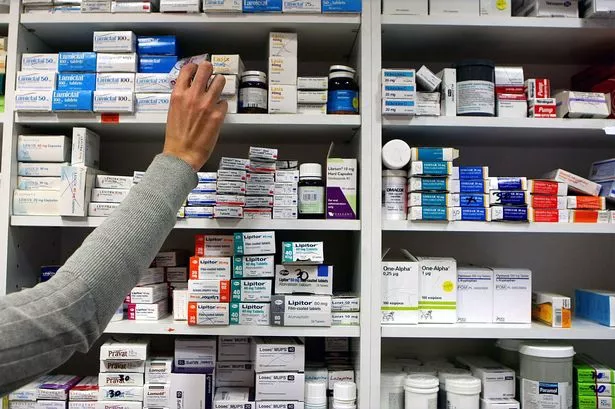 a pharmacist stocking shelves at a chemist.