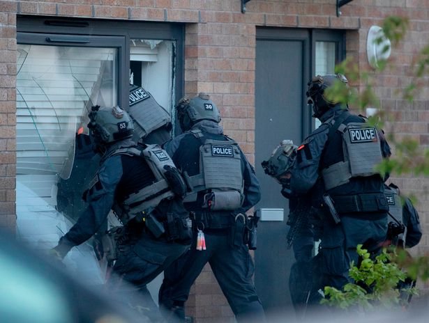Cops stepped into the house after hacking the window beams away