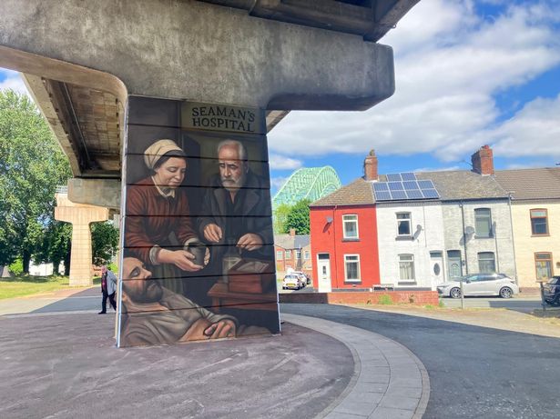 There are several murals being painted on the concrete pillars