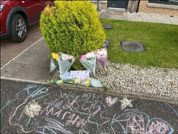 Floral tributes and drawings were left outside the home