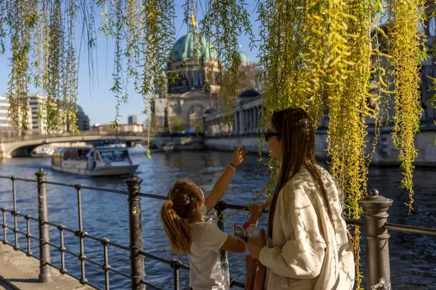 People enjoy the sun near Museum Island in Berlin, Germany