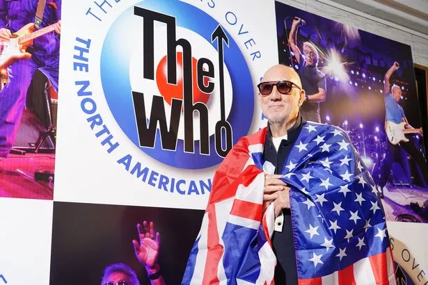 Pete Townshend drapes a flag of the United States over his shoulders at the Iconic Images Gallery in London during a special announcement about The Who