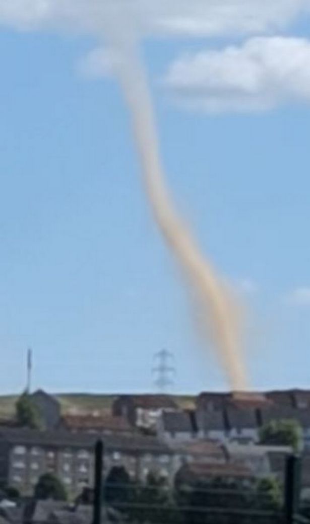 A still from a video showing a vertical dust cloud over a housing estate.