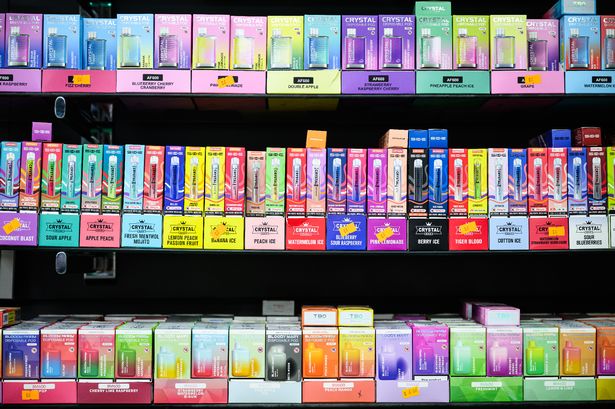 A selection of disposable vapes with bright and colourful packaging are seen in a convenience store