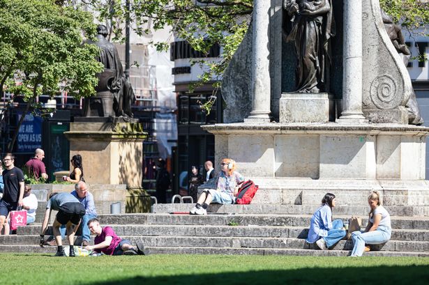 People enjoy the sun in Manchester's Piccadilly Gardens 