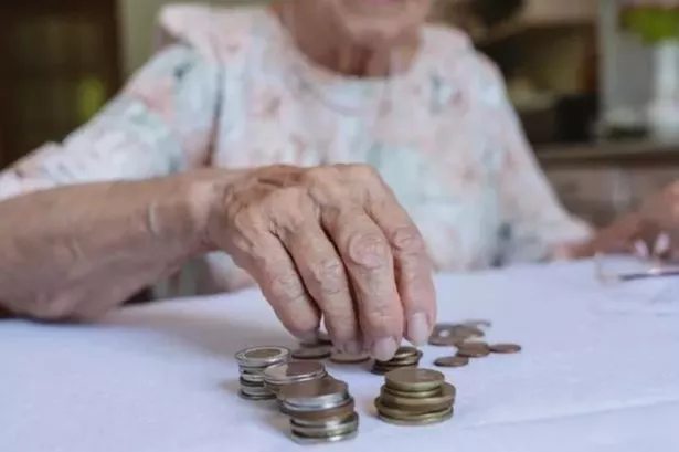 A pensioner counting money on a table