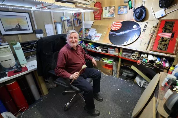 Ken Bullock in his studio holding a paintbrush 