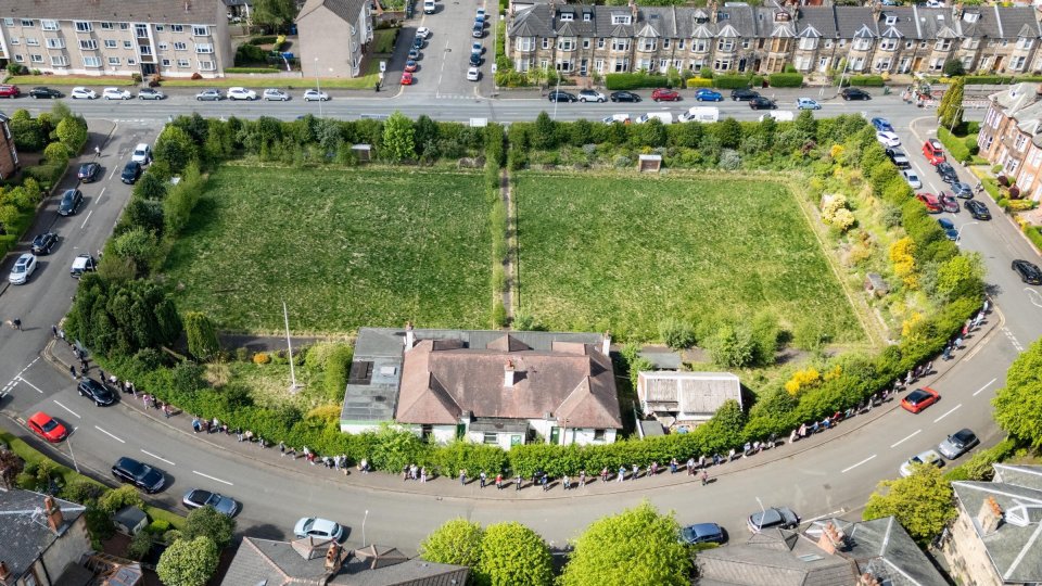Aerial view of Mount Florida residents forming a human chain around a bowling club to protest a proposed development.