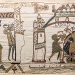 Part of ancient tapestry showing a king and his minions.