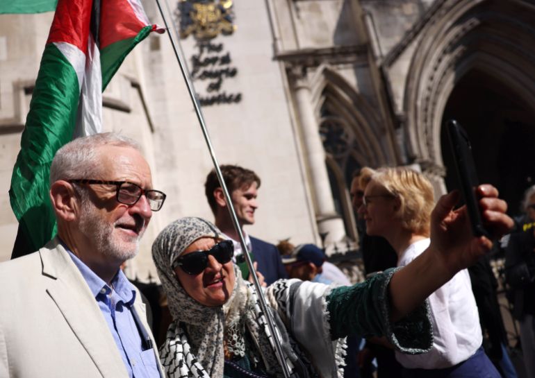 epa12095697 Former opposition Labour Party leader Jeremy Corbyn (L) poses for a selfie with a participant as he joins protesters demonstrating against selling arms to Israel at the Royal Courts of Justice in London, Britain, 13 May 2025. A four-day judicial review brought by Palestinian rights group Al-Haq and the Global Legal Action Network (GLAN) starts in the High Court on 13 May, with human rights' groups and lawyers arguing that UK's sale of arms to Israel is unlawful.  EPA-EFE/NEIL HALL