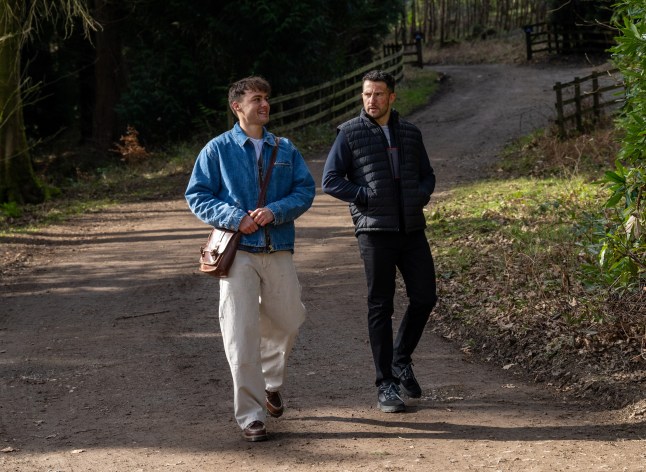Lewis walks with Ross through the village in Emmerdale