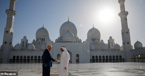 U.S. President Donald Trump shakes hands with Yousif Al Obaidli, director of Sheikh Zayed Grand Mosque, as he tours the mosque grounds in Abu Dhabi, United Arab Emirates, May 15, 2025. REUTERS/Brian Snyder