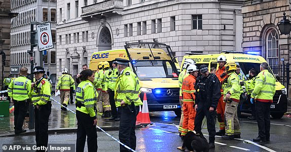 Police officers stand guard by the Liverpool Town Hall following an incident in Water Street (rear), on the sidelines of an open-top bus victory parade for Liverpool's Premier League title win, in Liverpool, north-west England on May 26, 2025. A car collided with a number of pedestrians in Liverpool, northern England, on May 26 evening during Liverpool FC's Premier League victory parade, police said. Police said they were contacted shortly after 6pm (1700 GMT) 'following reports of a collision between a car and a number of pedestrians' in the city centre. One man has been arrested, according to the police, who did not say whether there were any casualties. (Photo by Paul ELLIS / AFP) (Photo by PAUL ELLIS/AFP via Getty Images)
