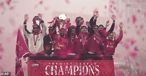 Liverpool players celebrate with the trophy on an open-top bus during the Liverpool FC Premier League victory parade in Liverpool, England, Monday, May 26, 2025.(AP Photo/Jon Super)