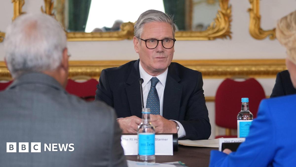 Sir Keir Starmer sitting at a table in Lancaster House, opposite European Commission President Ursula von der Leyen and European Council President Antonio Costa, who have their back to the camera.