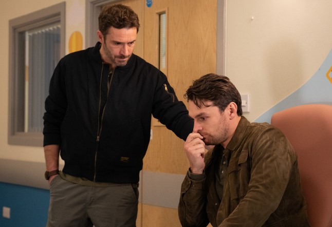 John comforts an upset-looking Mack on Emmerdale