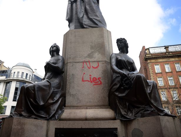 The memorial is daubed in red graffiti 