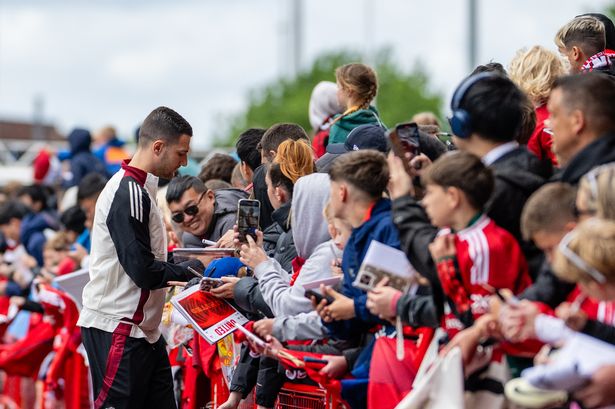 Diogo Dalot signs autographs for supporters.