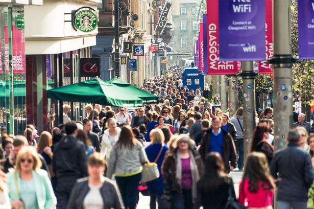Crowds of people passing shops and businesses on Buchanan Street, one of Glasgow's busiest shopping streets.