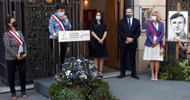 A woman on a platform speaks to a crowd at the ceremony in Paris to commemorate Dr Donald Caskie.