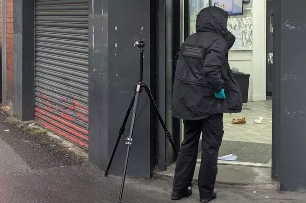 A forensics officer takes photos inside Supreme hair salon on Stockport Road, Ardwick. May 24, 2025