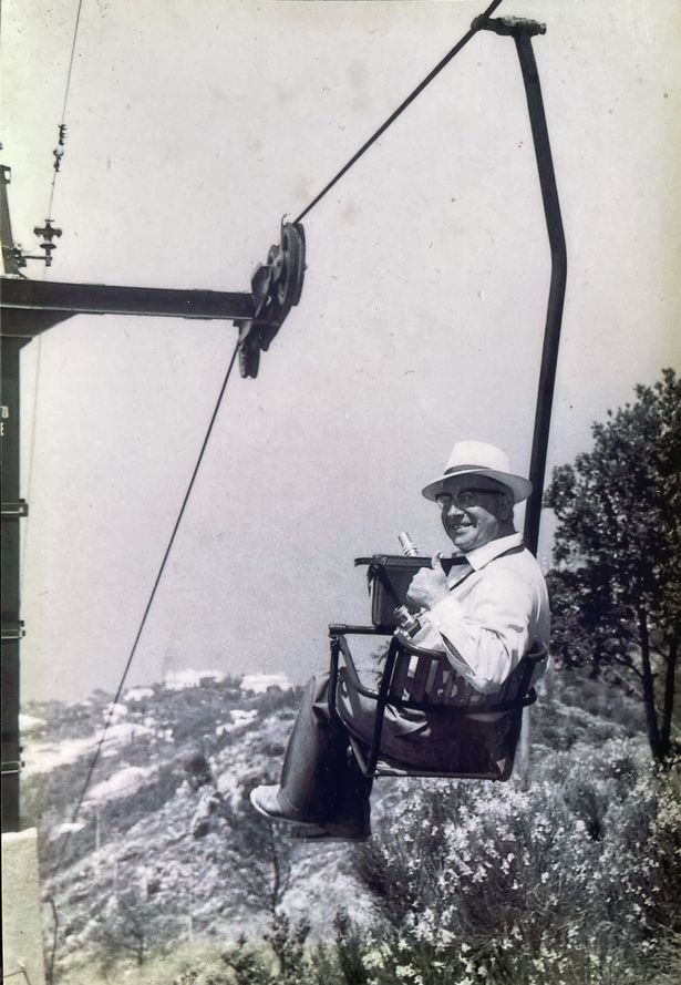 Fred Pedley on a chairlift in Capri with his camera, 1963