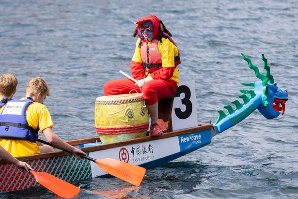 Boat with dragon head race down a part of Salford Quays to see who comes out on top