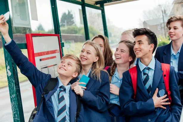 Group of teens taking a selfie in a bus stop after school