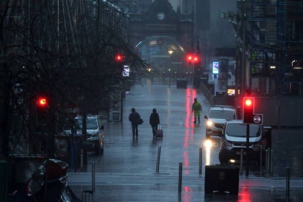 People walk in heavy rain on January 24, 2025 in Glasgow, Scotland, 