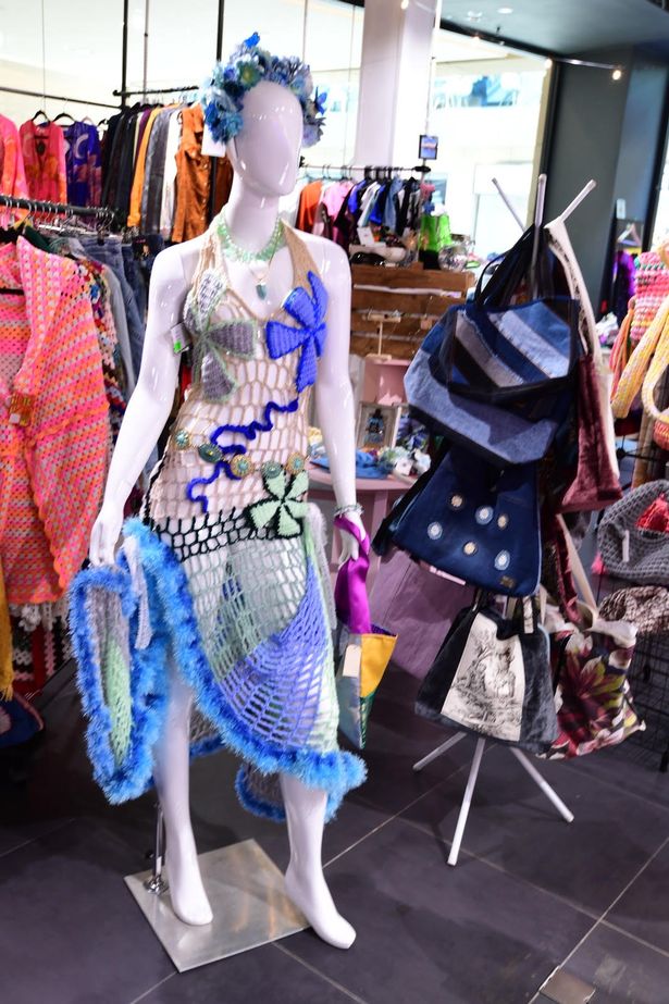This photo shows a multicoloured crochet dress on a mannequin. 