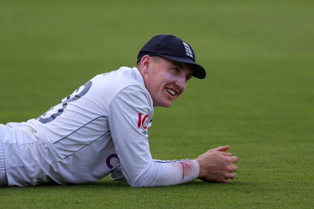 Harry Brook lies on the grass after diving in the field for England against Sri Lanka.