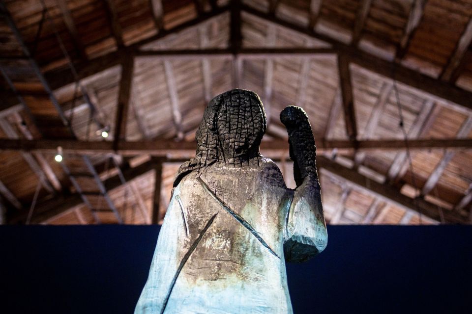 Charred wooden statue of Melania Trump on display.