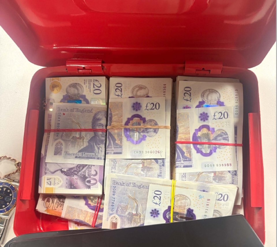 Stacks of twenty-pound notes in a red box.