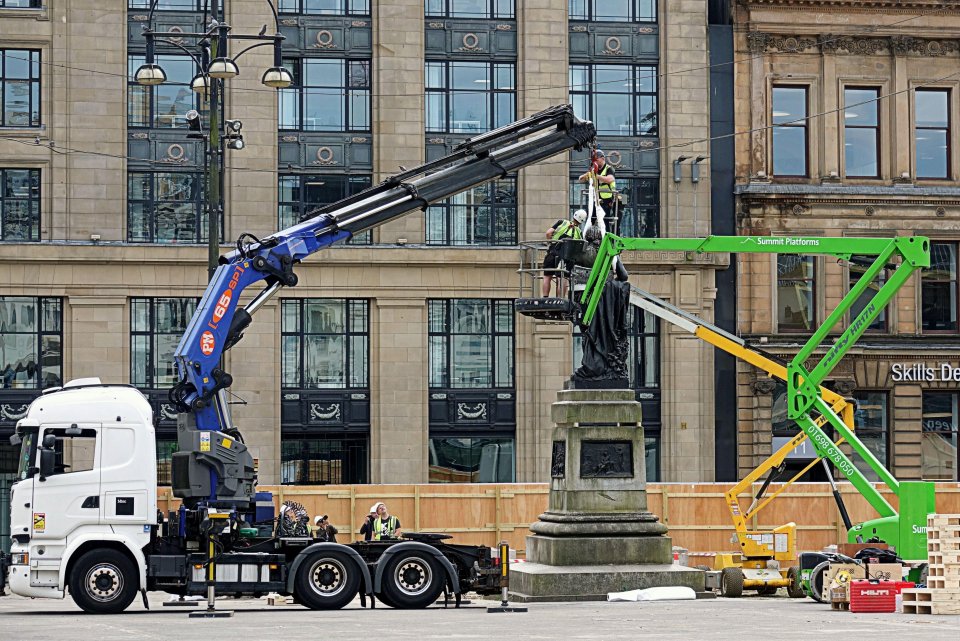 Removal of a statue from its pedestal using cranes.