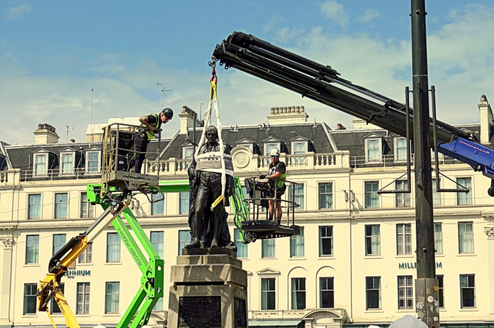 Workers using cranes to remove a Rabbie Burns statue during a George Square renovation.