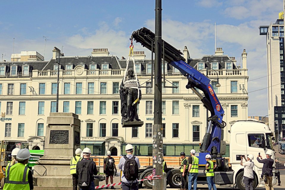 A crane lifts a statue of Robert Burns during renovations in George Square, Glasgow.