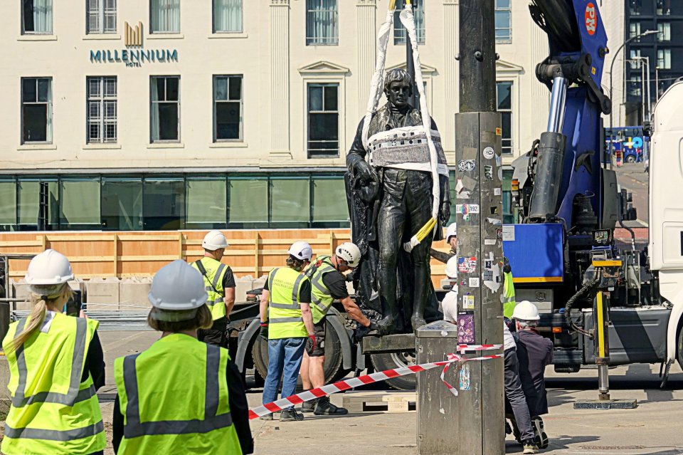 Workers removing a Rabbie Burns statue during a George Square renovation.
