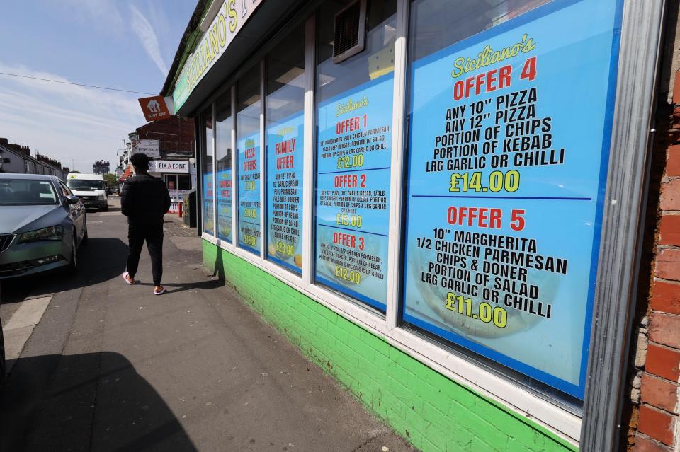 Siciliano's pizza shop window with various pizza offers.