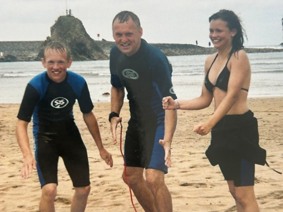 Photo of a brother, sister, and father on a beach.