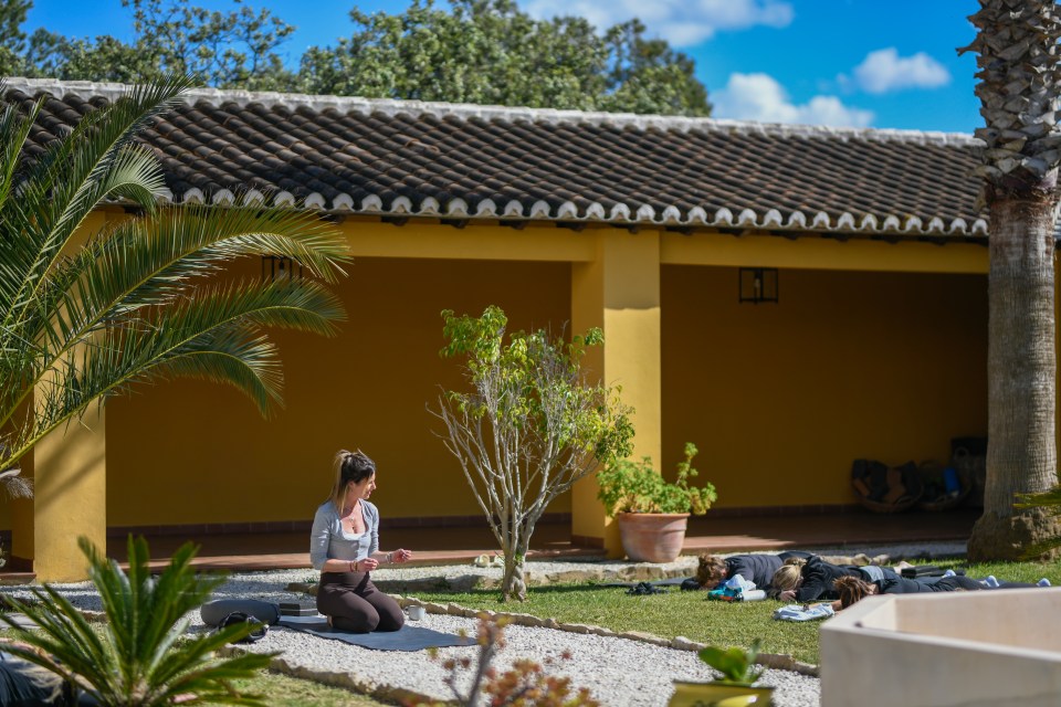 Woman leading a yoga class outdoors.