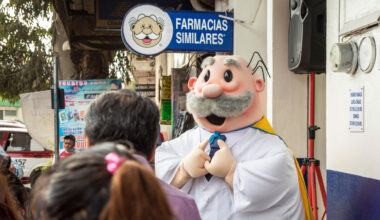 A person in a doctor costume solicits business for a Farmacias Similares store