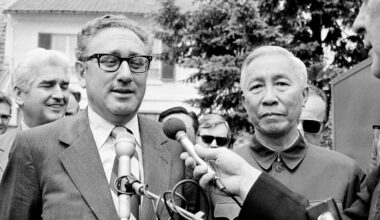 Henry Kissinger, left, and Le Duc Tho, speak to reporters after a negotiation session.