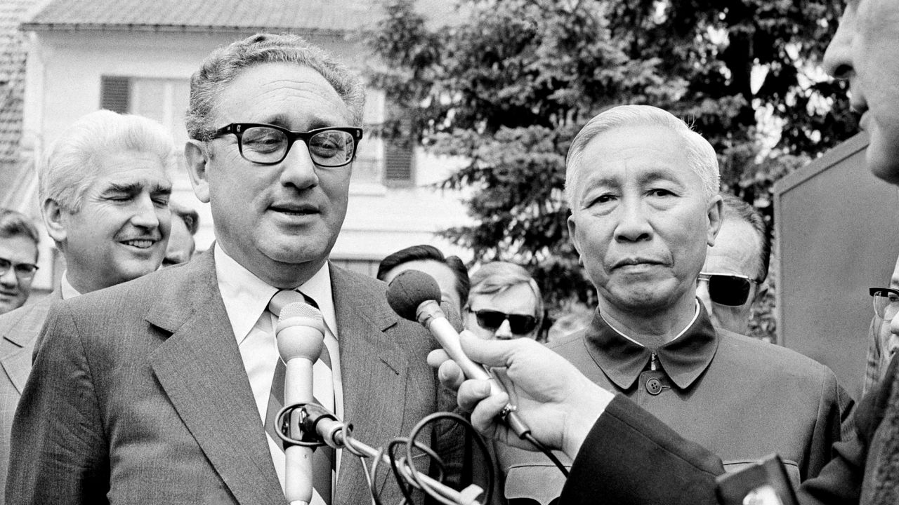 Henry Kissinger, left, and Le Duc Tho, speak to reporters after a negotiation session.