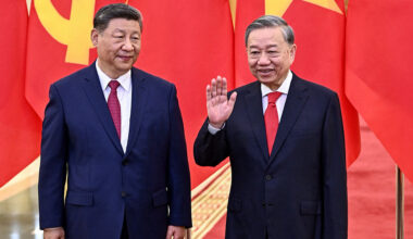 Vietnamese President To Lam waves while standing next to Chinese President Xi Jinping in Hanoi