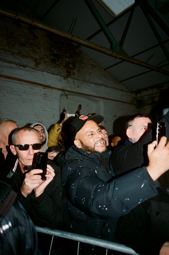 A crowd film people fighting