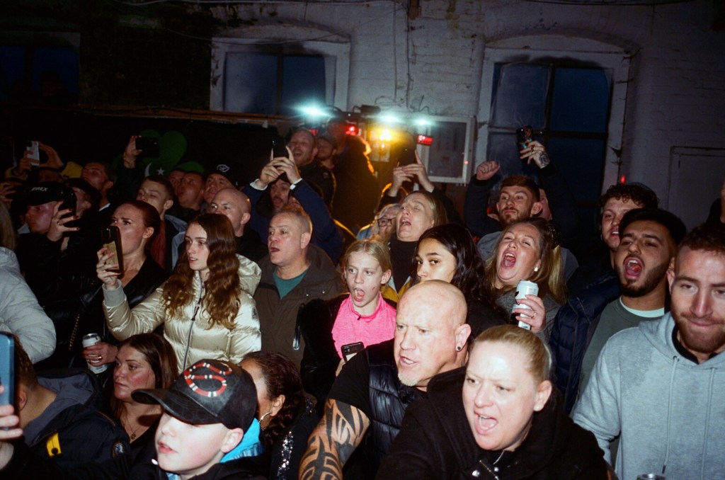 A crowd cheer on a fight